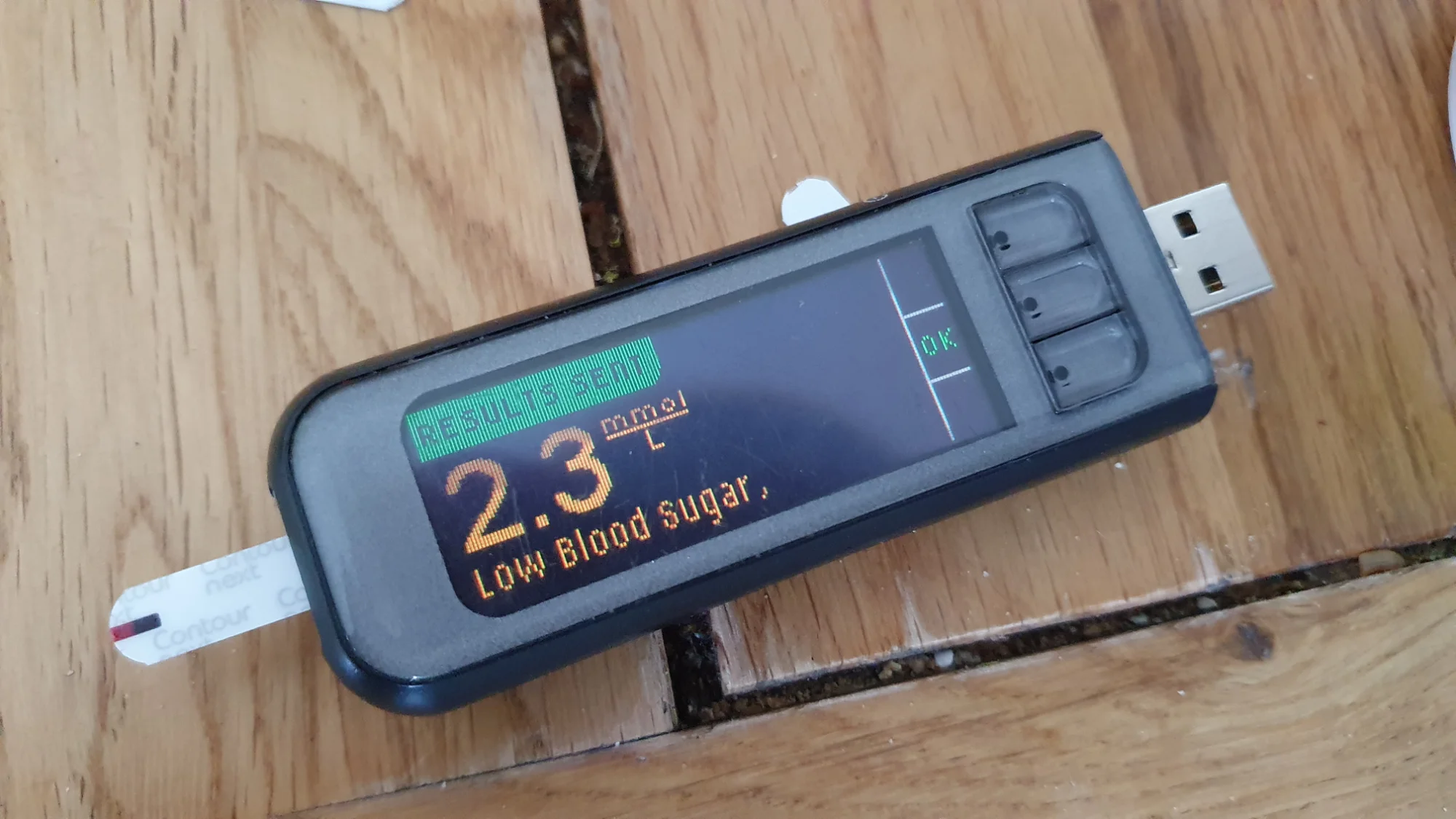 A usb device is sitting on a wooden table.